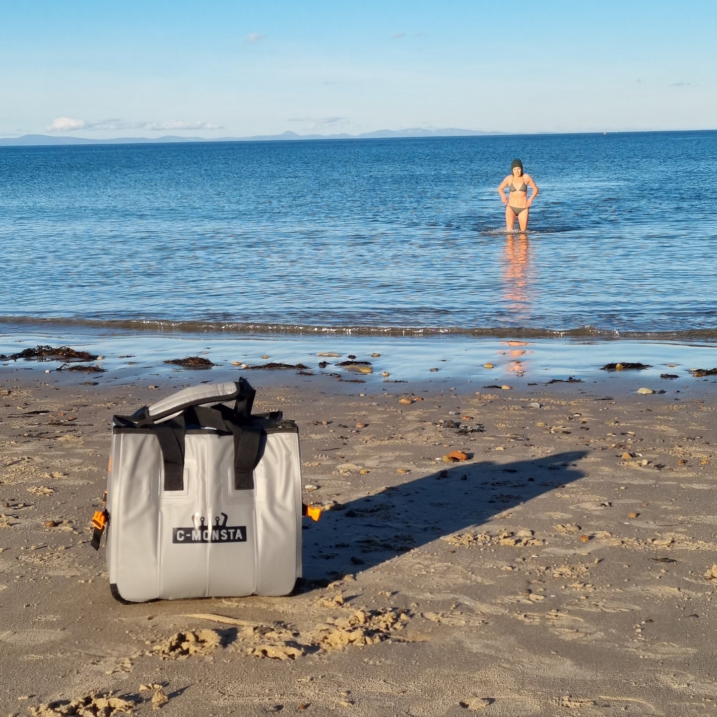 C-Monsta mini split bag – lifestyle beach shot with sea swimmer in the background